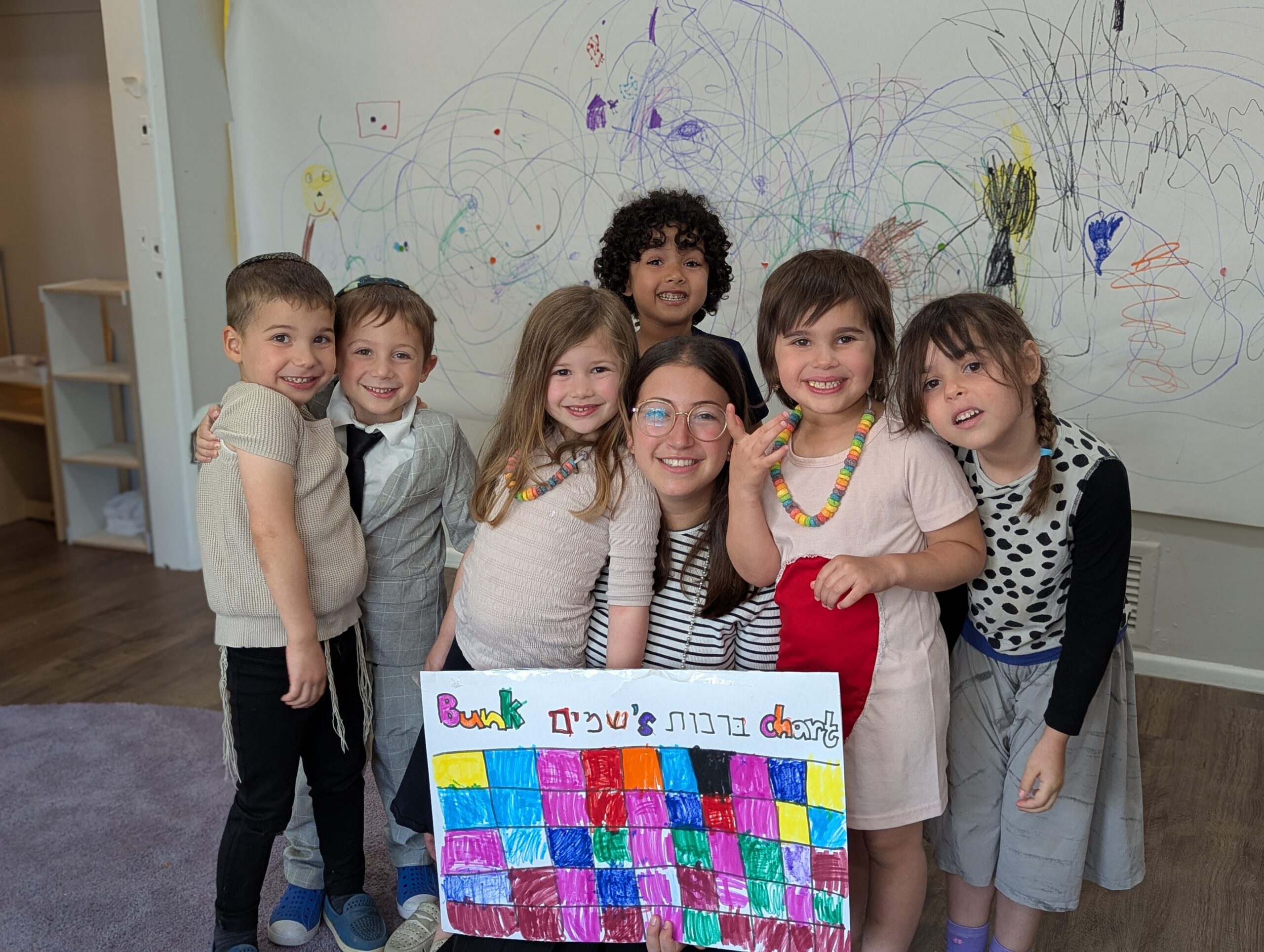 Group of happy campers wearing colorful clothing at a Camp Shemeshaz celebration or event