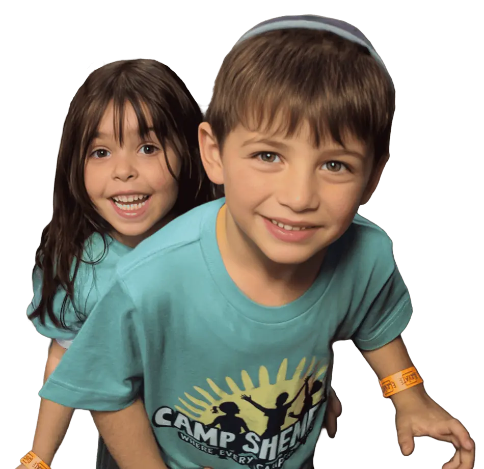 Two happy children at Camp Shemeshaz wearing green camp-branded t-shirts with sun and figures logo, and orange wristbands